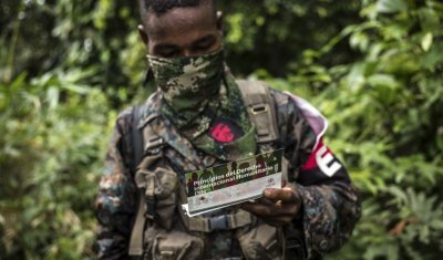 Colombia, Chocó Department. A member of the ELN armed group is reading an ICRC handout about the principles of the international humanitarian right and the obligation to respect the lives of the civilian population, health personnel, and the sick or wound